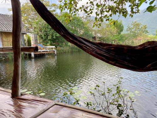 a hammock hanging over a body of water at Numpu Baandin in Sam Roi Yot