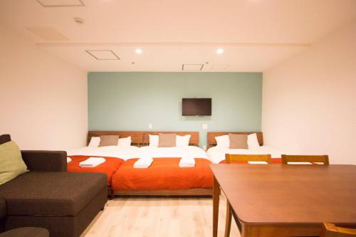 pokój hotelowy z łóżkiem i kanapą w obiekcie SEVEN Building / Vacation STAY 4953 w mieście Asahikawa