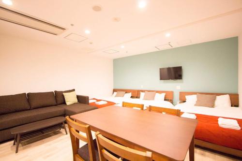 a living room with a couch and a table in a room at SEVEN Building / Vacation STAY 4953 in Asahikawa