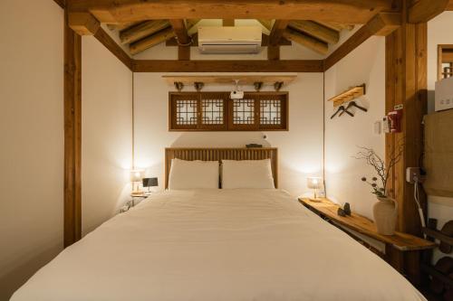 ソウルにあるLuxury hanok with private bathtub - SN11のベッドルーム(白い大型ベッド、ランプ2つ付)