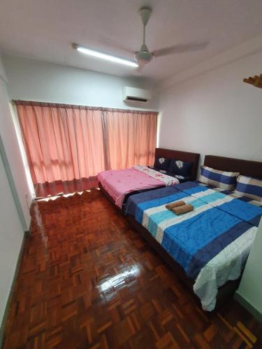 a bedroom with a bed with a blue comforter at Selesa Hillhomes Golf Resort - P4L1U in Bentong