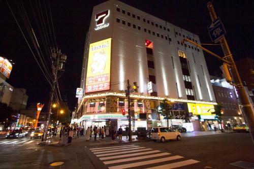 een groot gebouw aan een drukke stadsstraat 's nachts bij SEVEN Building / Vacation STAY 4950 in Asahikawa