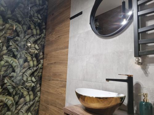 a bathroom with a wooden bowl sink and a mirror at Apartament Loft KB-Ściegiennego (garaż, centrum) in Kielce