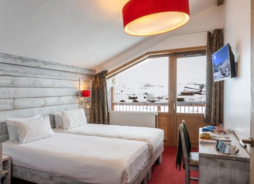 a hotel room with two beds and a window at Hôtel L'Aiguille Percée in Tignes
