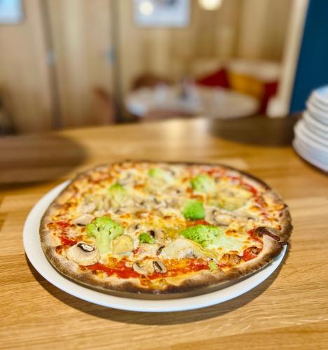 a pizza sitting on a plate on a table at ibis budget Besançon Centre Gare in Besançon