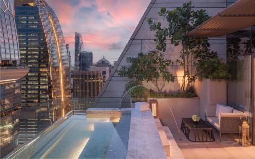 a rooftop pool on a building with a view of a city at Rosewood Bangkok in Bangkok