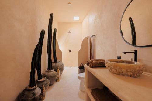 een badkamer met een wastafel, een toilet en een spiegel bij The Oasis Bali in Canggu