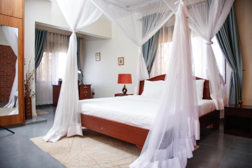 a bedroom with a bed with mosquito nets at Fred and Winnie BnB in Kampala