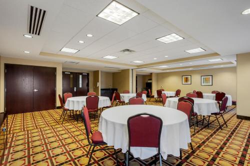 a conference room with white tables and red chairs at Comfort Inn & Suites Sayre in Sayre