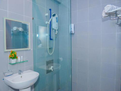 ein Bad mit einer Dusche und einem Waschbecken in der Unterkunft Treeline Urban Inn in Kota Kinabalu