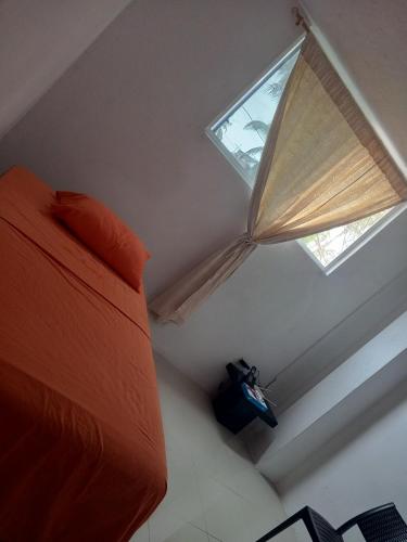 a bedroom with a bed and a window with a umbrella at Pelican Tours in Puerto Baquerizo Moreno