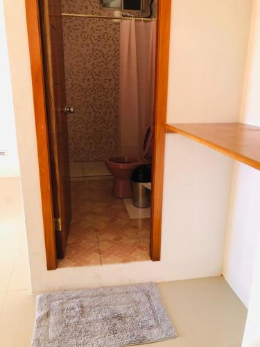a bathroom with a toilet and a door open at Pelican Tours in Puerto Baquerizo Moreno