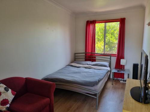 een slaapkamer met een bed, een stoel en een raam bij Beachside Backpackers in Port Macquarie