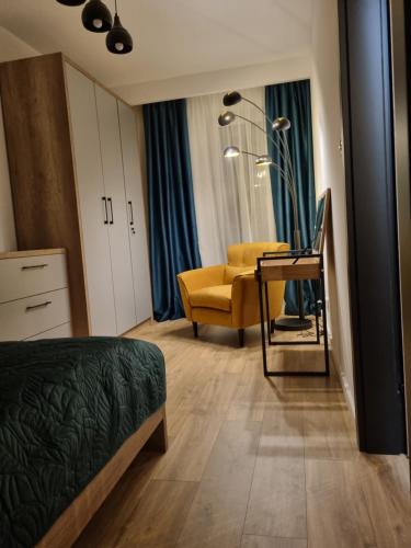 sypialnia z łóżkiem i żółtym krzesłem w obiekcie Apartament Loft KB-Ściegiennego (garaż, centrum) w Kielcach