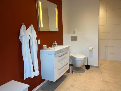 a bathroom with a white sink and a toilet at Nyopført luksusværelse i naturskønne og rolige omgivelser in Branderup