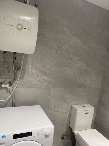 uma casa de banho com um WC branco e um lavatório. em Apartamento alto standing con piscina privada, aire acondicionado y wifi em Platja d'Aro