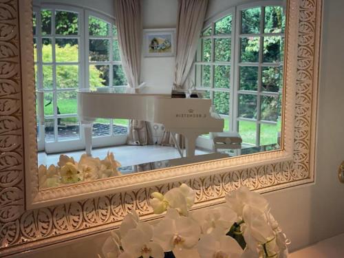 a large mirror in a living room with a piano at Villa Am Park in Bad Homburg vor der Höhe