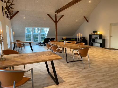 a dining room with wooden tables and chairs at Nyopført luksusværelse i naturskønne og rolige omgivelser in Branderup
