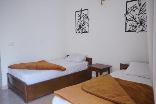 1 dormitorio con 2 camas y mesa con manta en Alaska Camp & Hotel, en Dahab