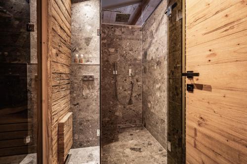 baño con ducha y puerta de cristal en Loft in the Alps Penthouse en Schwendau