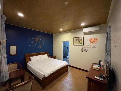 關山的住宿－關山福緣民宿，一间卧室设有一张床和蓝色的墙壁