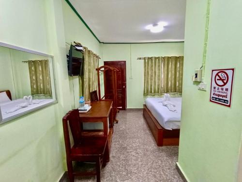 een kamer met een slaapkamer met een bed en een bureau bij โรงเกลือรีสอร์ท in Aranyaprathet