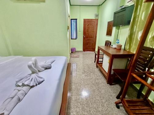 Zimmer mit einem Bett, einem Tisch und einem Spiegel in der Unterkunft โรงเกลือรีสอร์ท in Aranyaprathet