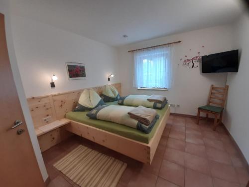 - une chambre avec un lit et une télévision dans l'établissement Zitas Ferienwohnung, à Reisach