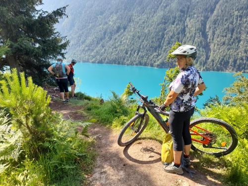 a woman holding a bike on a trail near a lake at Zitas Ferienwohnung in Reisach