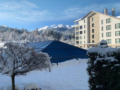 a blue tent in the snow in front of a building at Saint George Palace Aparthotel in Bansko