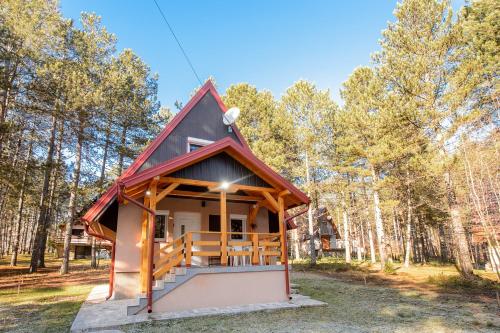 a tiny house in the woods with a red roof at Vila Šišarka Divčibare CENTAR in Divčibare
