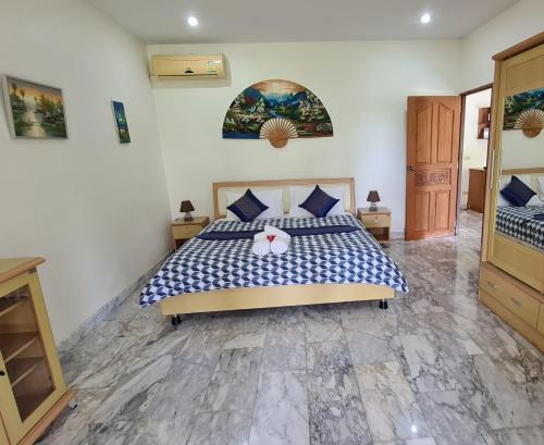 1 dormitorio con 1 cama con edredón azul y blanco en Beautiful bungalow with a communal outdoor pool and 2 km from the sandy beach, en Ban Sa