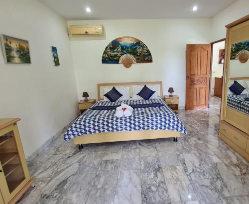 a bedroom with a bed with a blue and white comforter at Beautiful bungalow with shared outdoor pool and 2 km from the sandy beach in Ban Sa