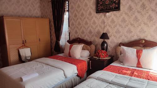 a hotel room with two beds in a room at Cendana Homestay in Sawahlunto