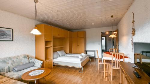 a living room with a bed and a table at Allgäu Appartementhaus Appartement ALLGÄU 02 in Pfronten