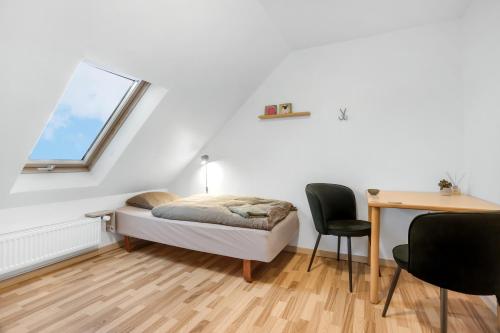 1 dormitorio con cama, escritorio y ventana en Storms Bed & Breakfast, en Herning