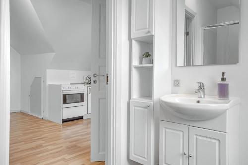 a white bathroom with a sink and a stove at Storms Bed & Breakfast in Herning