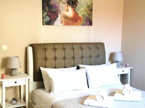 Un dormitorio con una cama con una pintura encima. en Odyseia Apts ΙI at the Center of the City & Old Town en La Canea