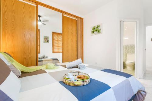 Habitación con 2 camas y un bol de fruta. en Lovely Holiday in Golf del Sur en San Miguel de Abona