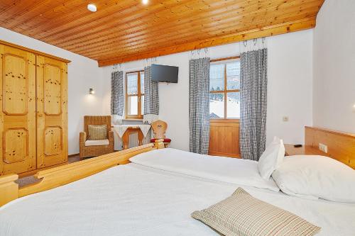 a bedroom with a large bed with a wooden ceiling at Haus Leiter in Reit im Winkl