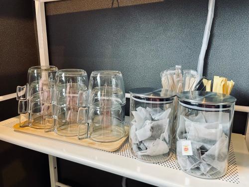 a shelf with several glass jars on it at Hostel SAMURISE 81INN in Fujikawaguchiko