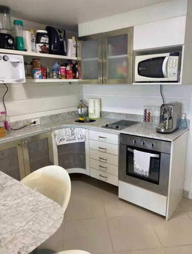 a kitchen with a stove and a microwave at ONDINA SSA in Salvador