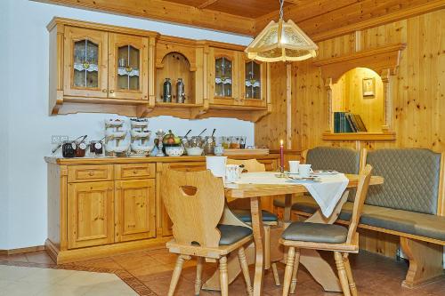 a kitchen with wooden cabinets and a table and chairs at Haus Leiter in Reit im Winkl