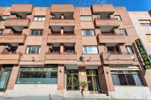 a red brick building with a front door at Hotel Victoria Valdemoro in Valdemoro