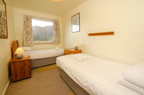 a bedroom with two beds and a window at 18 Thrang Brow in Ambleside