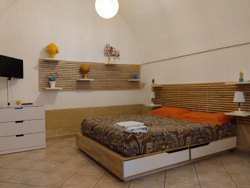 una camera con un letto e una televisione di Dimora Dioniso a Polignano a Mare