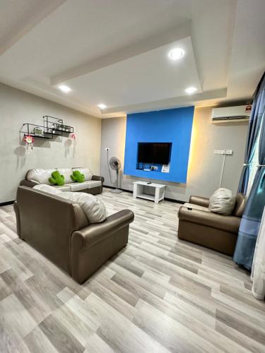 sala de estar con 2 sofás y TV de pantalla plana en ANG LEE HOLIDAY HOME 1 en Semporna