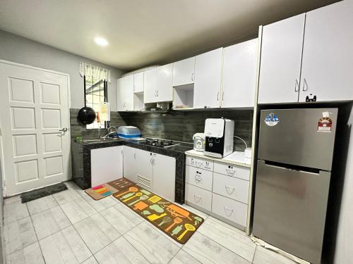 センポルナにあるANG LEE HOLIDAY HOME 1のキッチン(白いキャビネット、ステンレス製の冷蔵庫付)