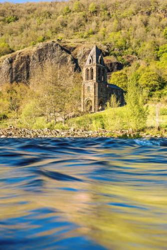 an old church on the side of a body of water at Château de Saint Vidal in Le Puy en Velay