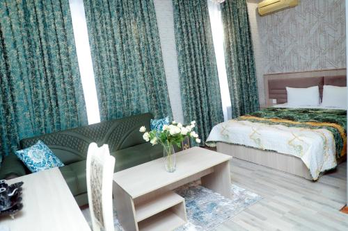 a hotel room with a bed and a couch and a table at RamRamay in Qax
